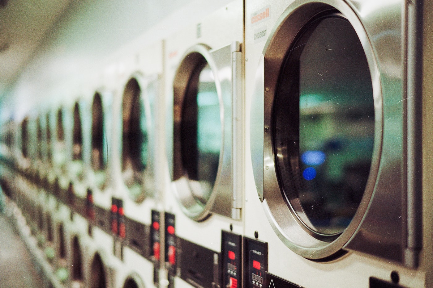 Professional machines lit up as garments run through a careful specialty cleaning cycle